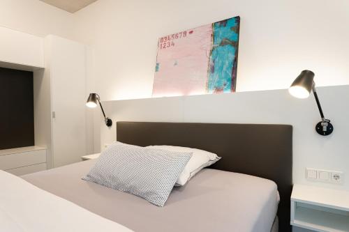 een slaapkamer met een bed met twee lampen aan de muur bij Refugium am Wasserturm in Emsdetten