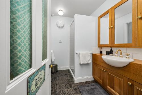 a bathroom with a sink and a mirror at Coopers Cottage Battery Point in Hobart