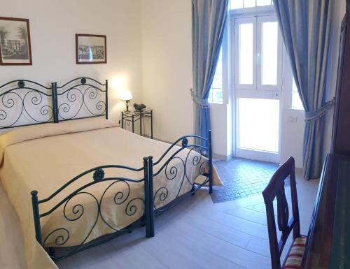 a bedroom with a bed and a window and a door at Hotel Parco Dei Principi in Anzio