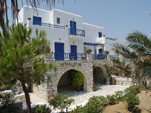 a white building with blue windows and a stone bridge at Ragoussis House in Logaras