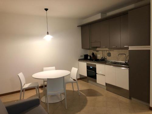 uma cozinha com uma mesa branca e cadeiras num quarto em Vecchia Filanda em Thiene