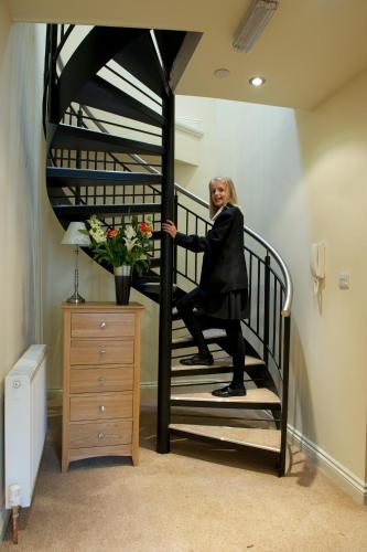 a woman is standing on a spiral staircase at Waterfront Apartments in Douglas