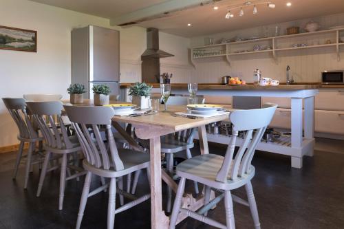 cocina con mesa de madera y sillas en Crucis Park Estate, en Cirencester