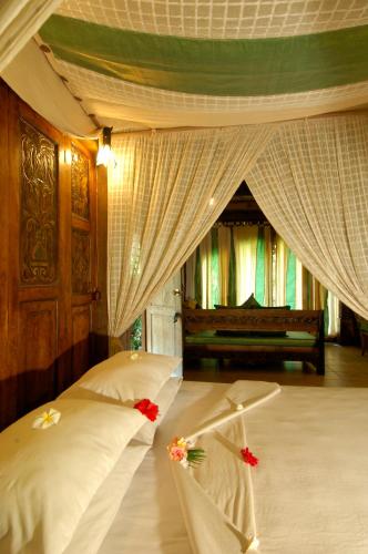 a bedroom with two beds with flowers on them at Hotel Pondok Sari Beach & SPA Resort in Pemuteran