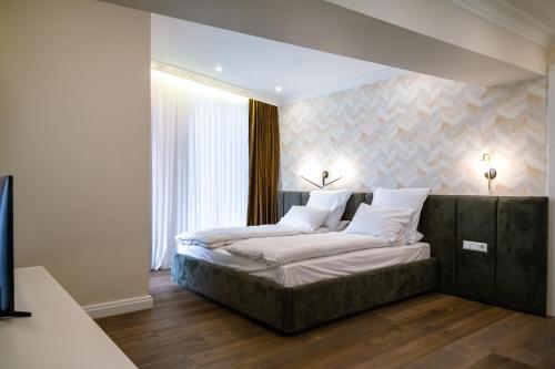 a bedroom with a bed with white sheets and pillows at Casa Viilor in Chişinău