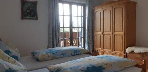 a bedroom with a window and two pillows on a couch at Wein- und Weitblick in Gleinstätten