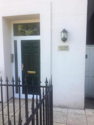 a black door on a white house with a sign on it at Luxury City Centre Apartment, Exeter. in Exeter