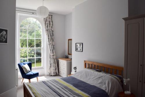 a bedroom with a bed and a window and a chair at Luxury City Centre Apartment, Exeter. in Exeter