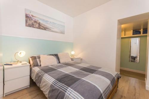 um quarto com uma cama e uma cómoda com um candeeiro em Apartment Ger y Bae sleeps 2 em Cemaes Bay