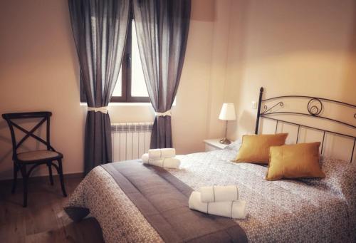 a bedroom with a bed with yellow pillows and a window at Casa del maestro in Orbita