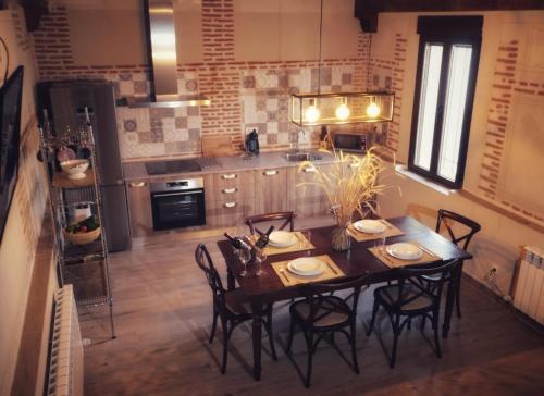 a kitchen with a wooden table and chairs in a room at Casa del maestro in Orbita