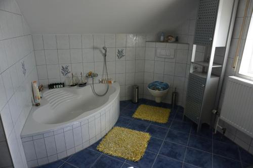 La salle de bains est pourvue d'une baignoire et de toilettes. dans l'établissement Ferienhaus Englburg in absolut ruhiger Lage, à Tittling