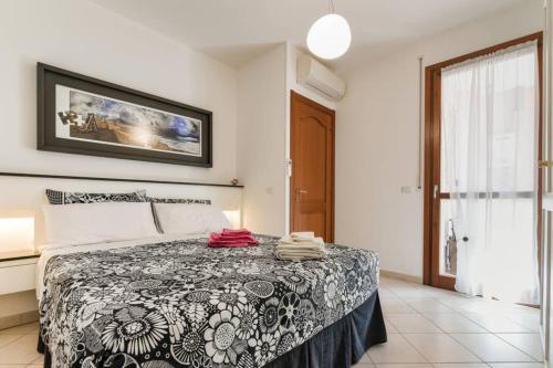 a bedroom with a bed with a black and white blanket at Delizioso appartamento ad Alghero in Alghero