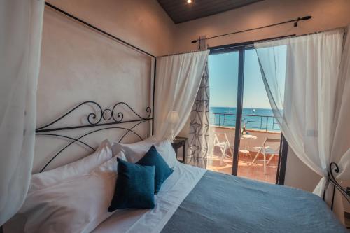 
a bedroom with a large bed and a large window at B&B Marranzano in Giardini Naxos
