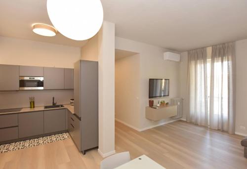a kitchen with white cabinets and a large window at CASA DOM-PEDRO in Rivarolo Canavese