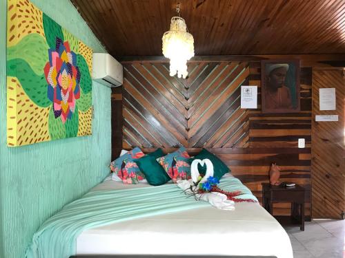 a bedroom with a bed with a wooden wall at Pousada Alto Astral in Olinda