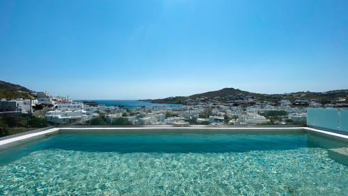 a swimming pool with a view of a city at Amperian Mykonos Suites & Villas in Mýkonos City