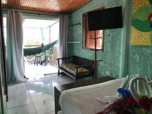 een slaapkamer met een bed en een televisie in een kamer bij Pousada Alto Astral in Olinda