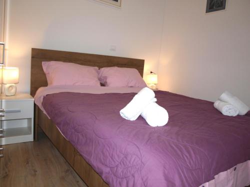 sypialnia z purpurowym łóżkiem z 2 białymi poduszkami w obiekcie Apartment MONTE w Rovinj