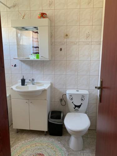 a bathroom with a toilet with a smiley face drawn on it at Eko Penzion Leo in Dudince