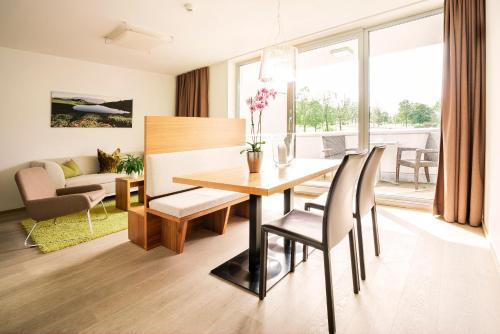 jadalnia i salon ze stołem i krzesłami w obiekcie Tauernresidence Radstadt by ALPS RESORTS w mieście Radstadt