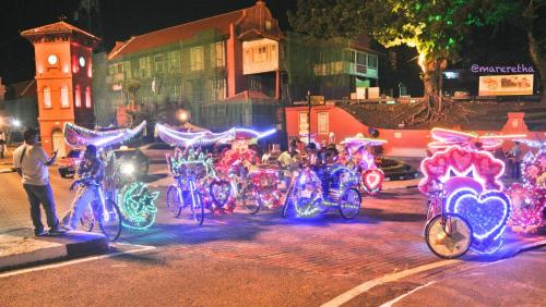 un grupo de bicicletas decoradas con luces en una calle en JOKA-JOKA GUESTHOUSE, en Melaka