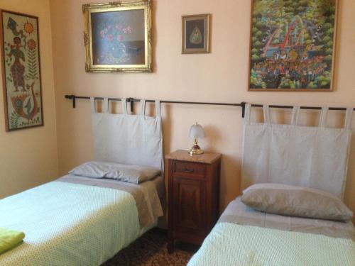 1 dormitorio con 2 camas y mesa con lámpara en LA BARRIERA affittacamere en Florence