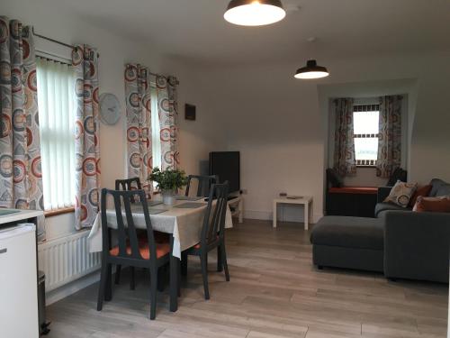 a living room with a table and chairs and a couch at Binnian View Apartment in Kilkeel