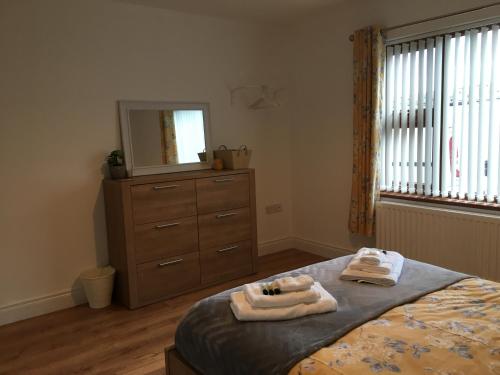 a bedroom with a bed and a dresser and a mirror at Binnian View Apartment in Kilkeel