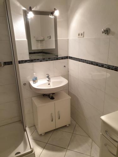 a white bathroom with a sink and a mirror at Renoviertes Wohlfühlapartment in Hagen