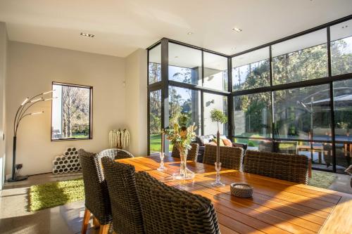 a dining room with a wooden table and chairs at The Jewel of Akatarawa in Upper Hutt