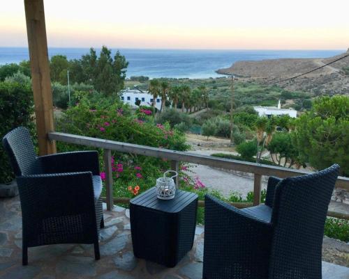 eine Terrasse mit Stühlen und einem Tisch mit Meerblick in der Unterkunft Anthia Apartment Sea View in Káto Zákros