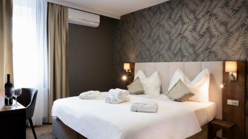 a hotel room with a large bed with white pillows at Hotel Karolina in Lanškroun