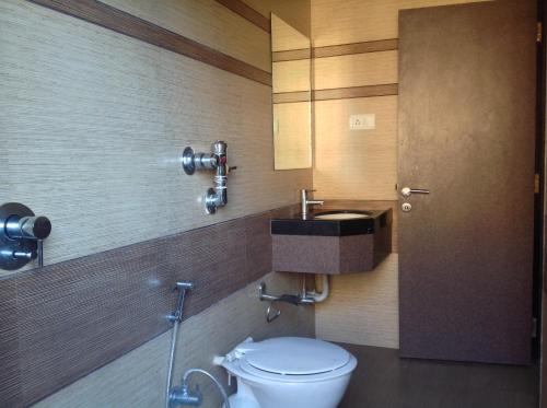 a bathroom with a toilet and a sink at Pals Hotel in Mumbai