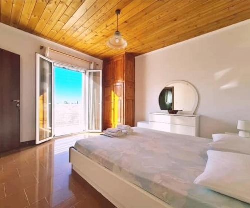a large bedroom with a large bed and a large window at Irini Studios in Alykes