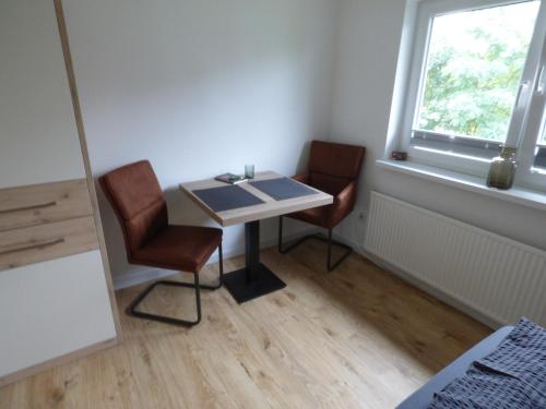 a table and two chairs in a room with a window at Poseidon in Nebel