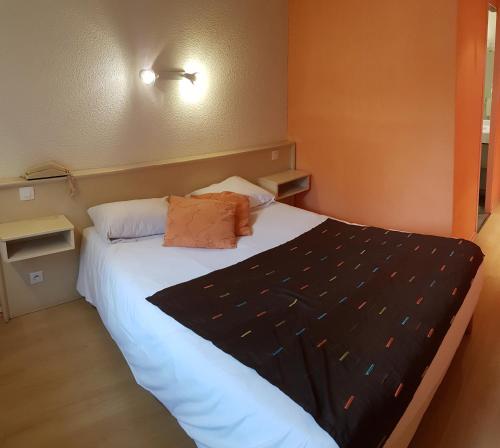 a small bedroom with a bed with white sheets at Hôtel La Bérangère in Pérouges