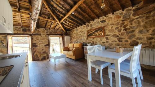 una cucina e una sala da pranzo con tavolo e sedie bianchi di Casas del Castillo, 2 ad Ávila