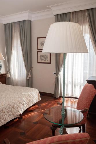 a bedroom with a bed and a table with a lamp at Relais Ducale in Gubbio