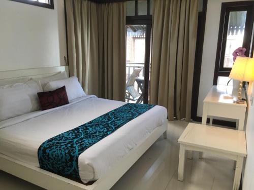 1 dormitorio con 1 cama grande y balcón en THE LAGOON WATER CHALET en Kampung Padang Masirat