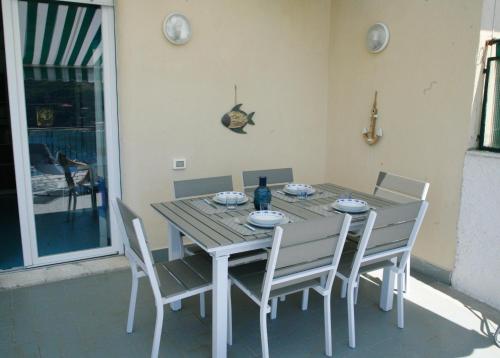 a dining room table with white chairs and a table and chairsktop at La Casa di Letizia in Levanto