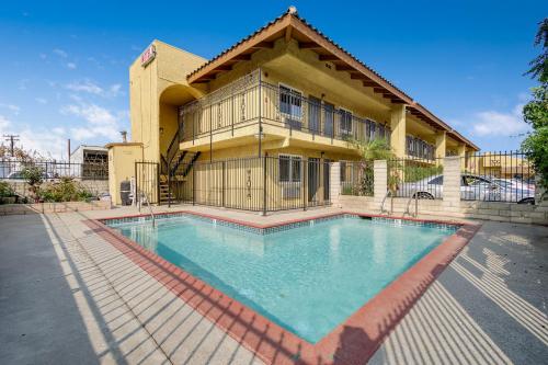 a large swimming pool in front of a house at Hacienda Inn in La Puente