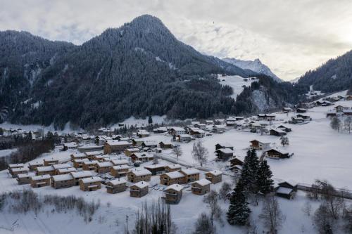 Chalet-Resort Montafon في سانكت غالنكرش: قرية مغطاة بالثلج مع جبال في الخلفية