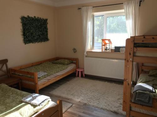 a bedroom with two bunk beds and a window at 21 és fél Fenyő Vendégház in Matraszentlaszlo
