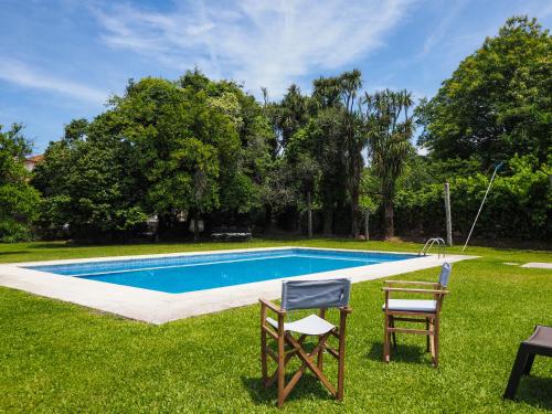 a swimming pool with two chairs and a table at Casa da Vinha in Arcos de Valdevez
