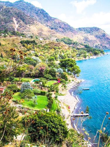 a view of a beach with trees and the water at Casa Paxanax in Santa Cruz La Laguna