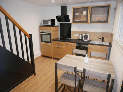 une cuisine avec une table en bois et une table et des chaises dans l'établissement Maison cœur de ville esprit industriel - Le Loft12, à Châteauroux