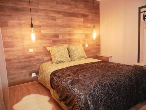 een slaapkamer met een bed met een houten muur bij Maison cœur de ville esprit industriel - Le Loft12 in Châteauroux