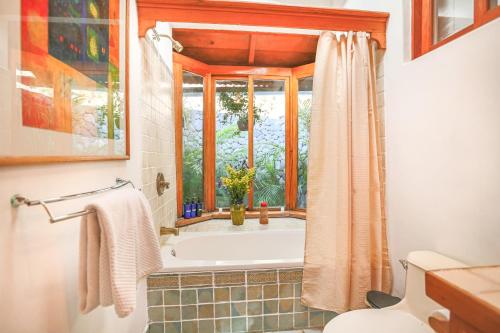 baño con bañera y ventana en Casa Paxanax, en Santa Cruz La Laguna