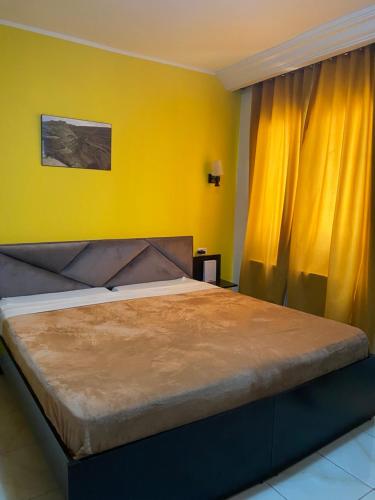 1 dormitorio con 1 cama grande y pared amarilla en Hotel Métropole Résidence, en Túnez